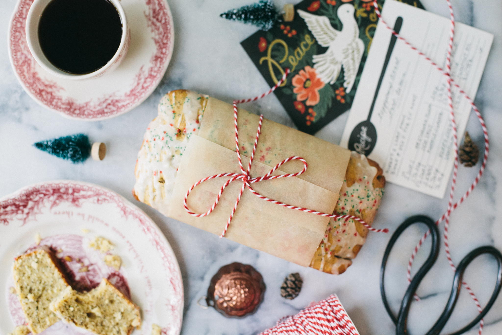 Photo of a loaf of poppy seed bread on a marble board with holiday decorations