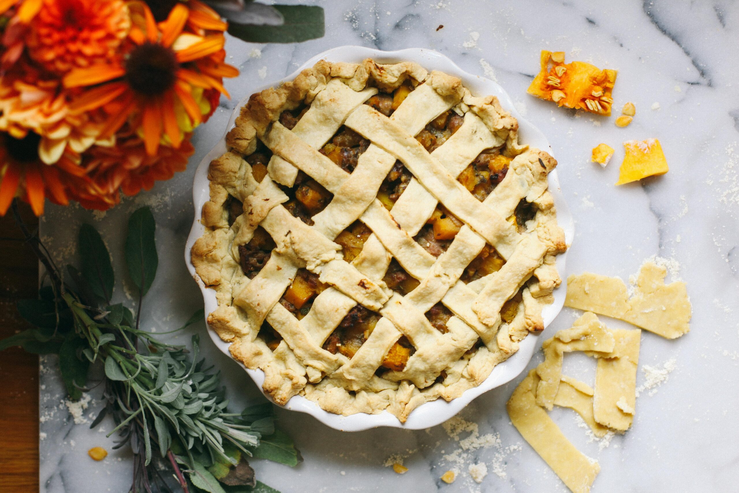 photo of a sausage and squash pie sitting on a marble cutting board