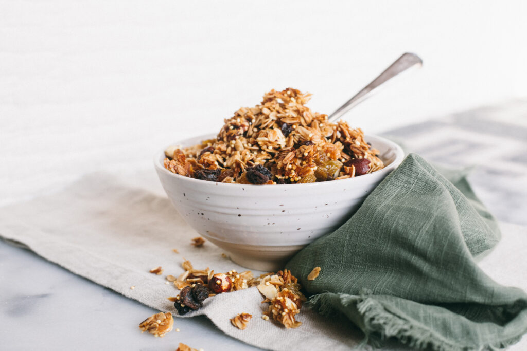 Photo of a bowl of granola on a marble cutting board with a green linen napkin