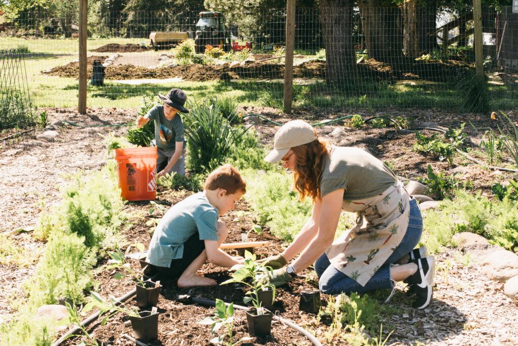 Image of a woman planting in the garden with her two children