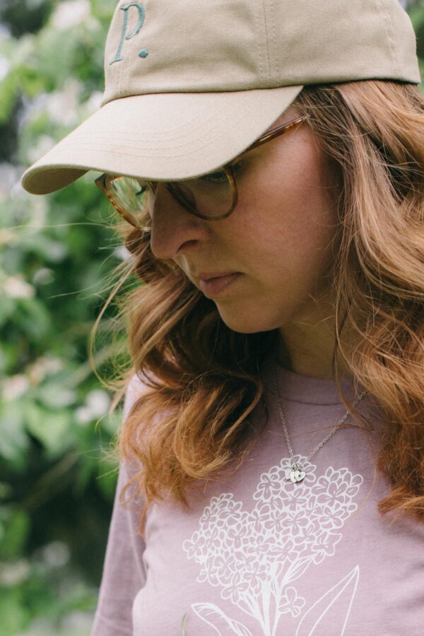 Image of a woman in a lilac t-shirt wearing a Potager Online Gardening Hat