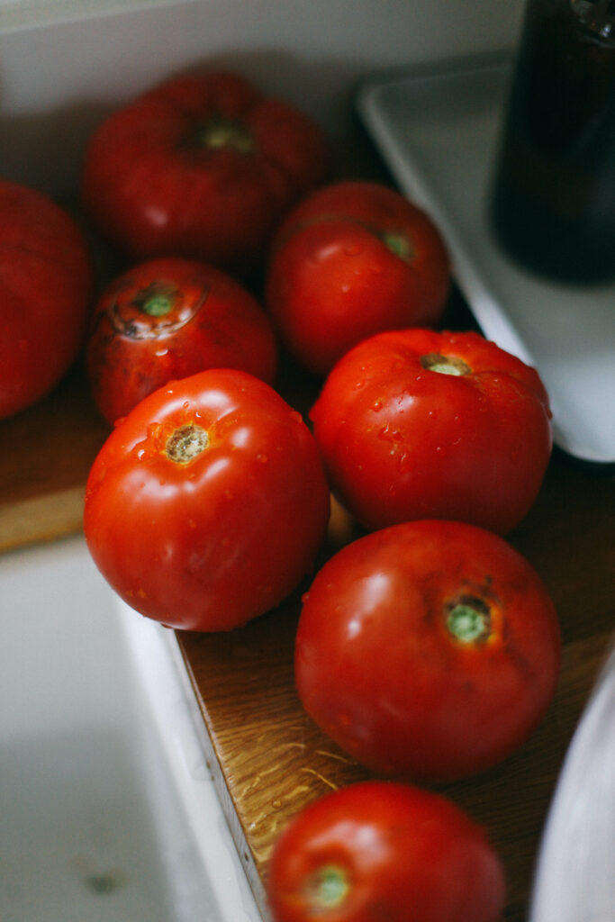 Photo of a row of red tomatoes next to a farm sink