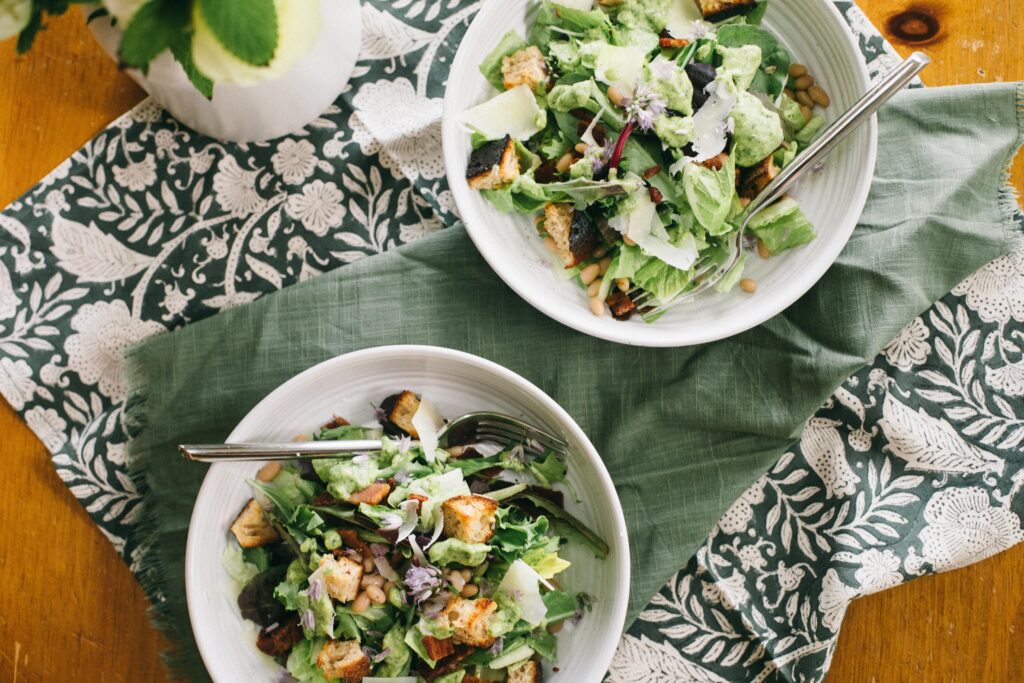 Image of two Garden Chop Salads with Green Goddess Dressing on a table with a green napkin