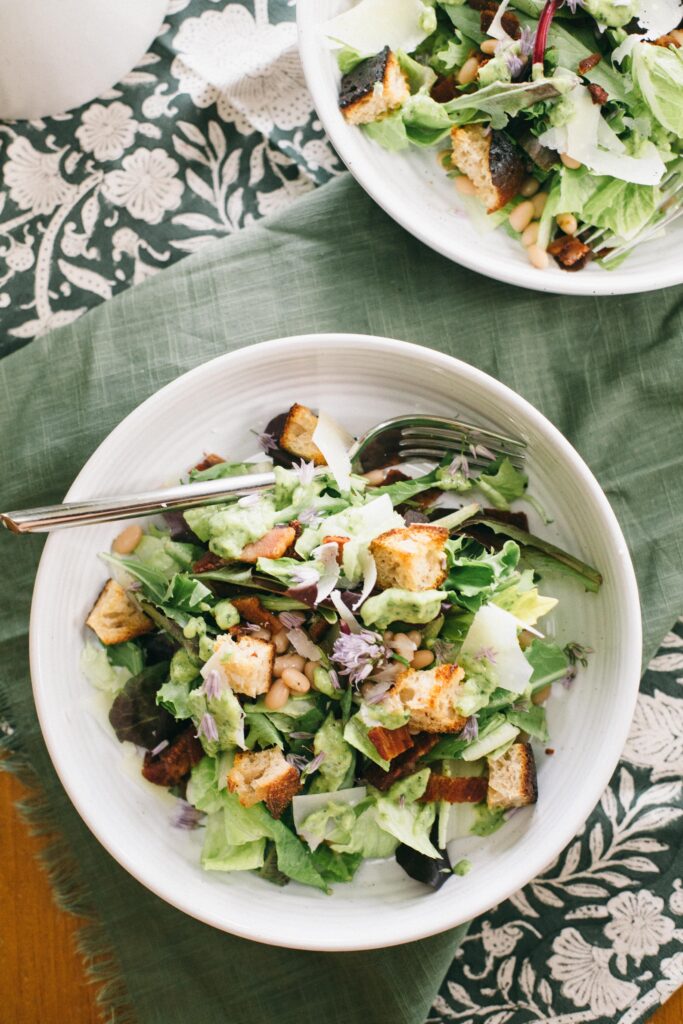 Image of a Garden Chop Salad with Green Goddess Dressing in a white salad bowl on a green napkin