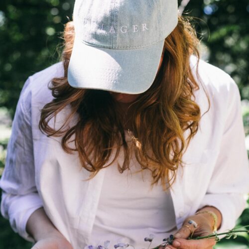 Image of a woman in a white shirt wearing the Potager Denim Hat
