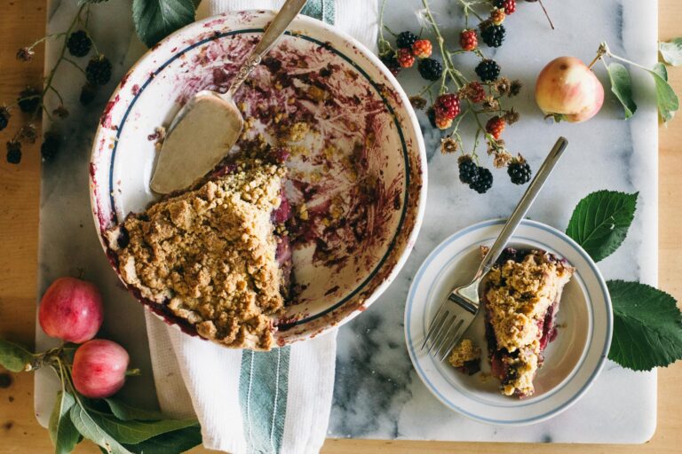 Image of a Blackberry Apple Crumble Pie on a marble board on a table