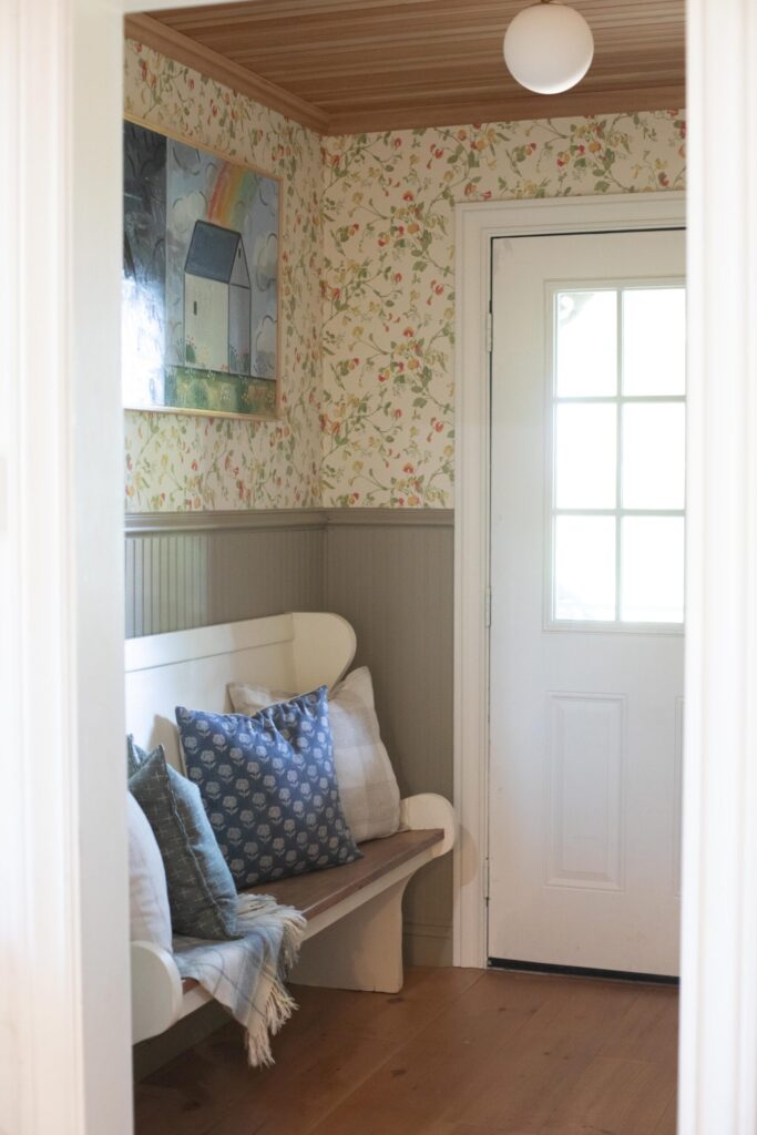 Image of a secondhand entry bench with cozy throw pillows and a blanket