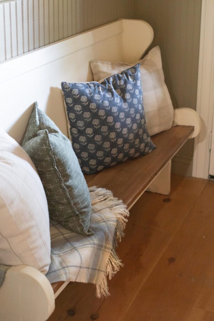Image of a secondhand bench filled with cozy throw pillows and blankets
