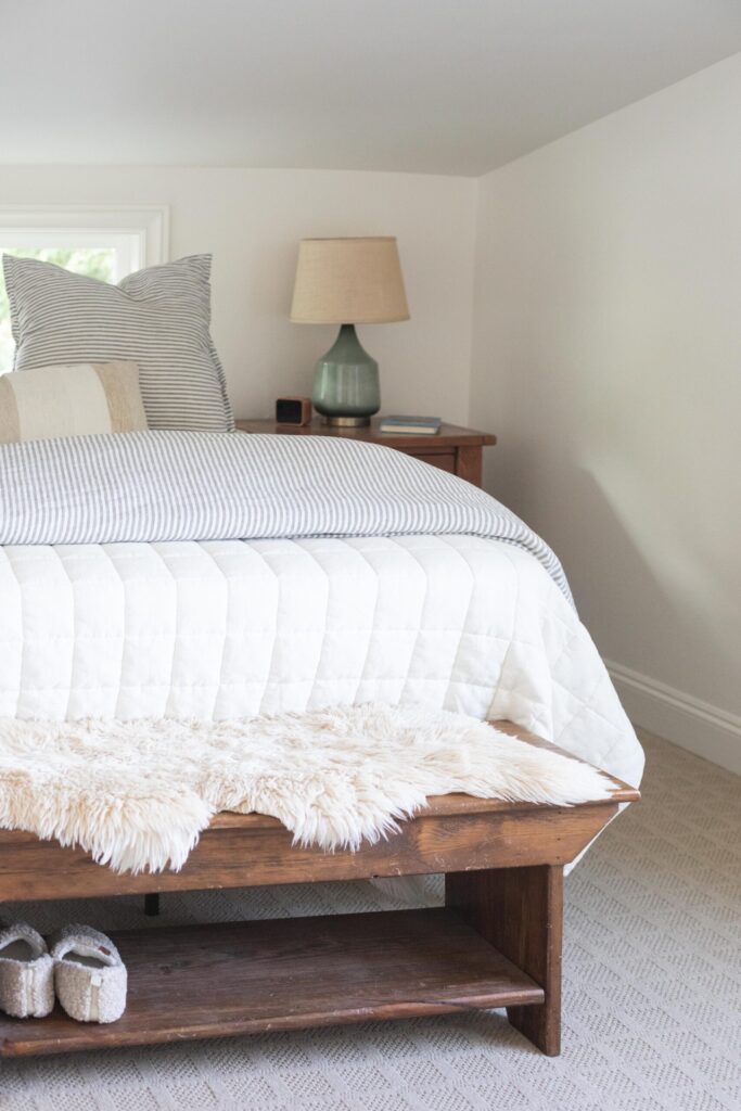Image of an attic bedroom decorated with secondhand furniture and linens