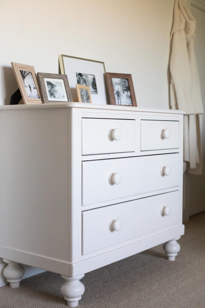 Image of a secondhand dresser with thrifted picture frames and black and white photos