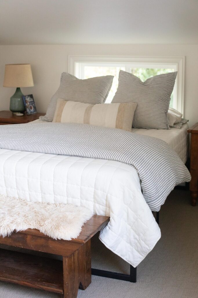 Attic bedroom decorated in neutral colors with secondhand furniture