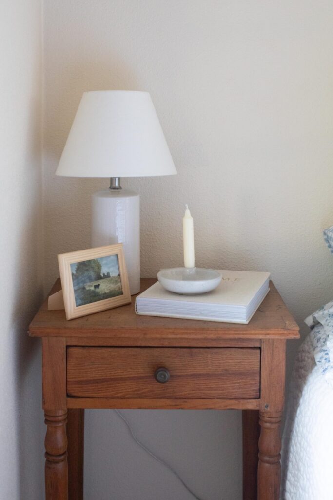 Image showing a secondhand side table with lamp, candle and book