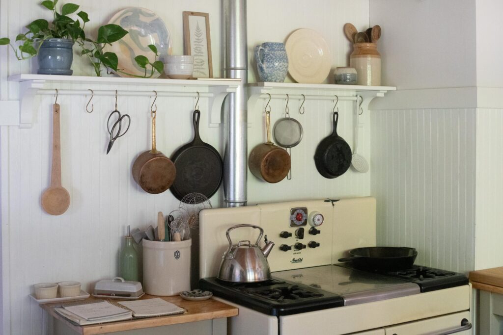 Image of kitchen shelves filled with secondhand treasures over a vintage stove in a Swedish Cottage Kitchen