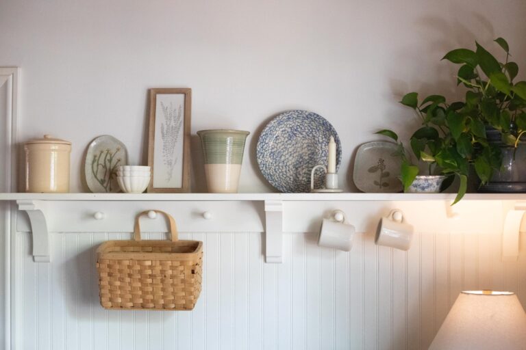 Image of a shelf in a Swedish Cottage kitchen filled with secondhand and thrifted pottery, dishes and baskets