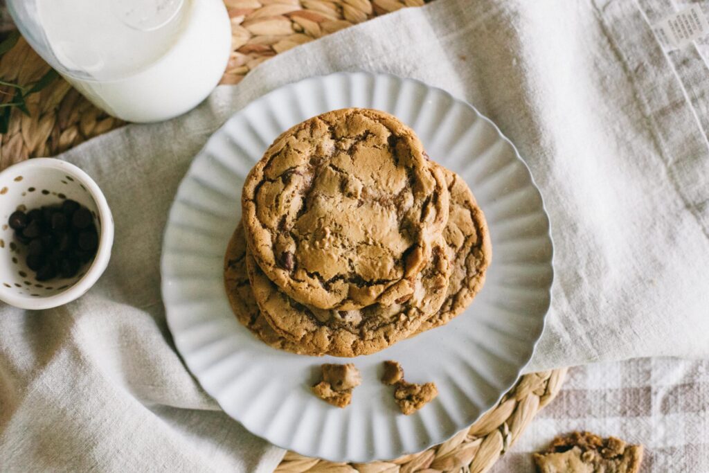 Image of a plate of cookies, glass of milk, and post with a recipe for an Einkorn Chocolate Chip Cookie