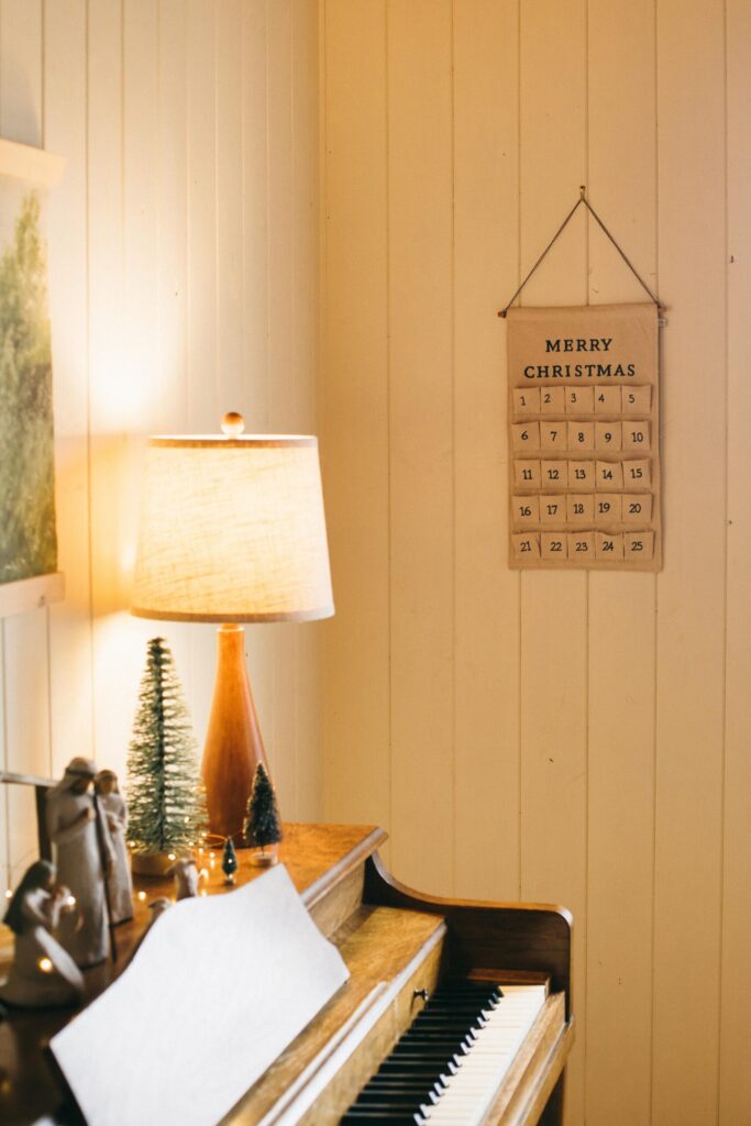 Image of a piano with a Willow Tree nativity set and Hearth & Hand Advent Calendar in a cozy, calm Cottage Christmas