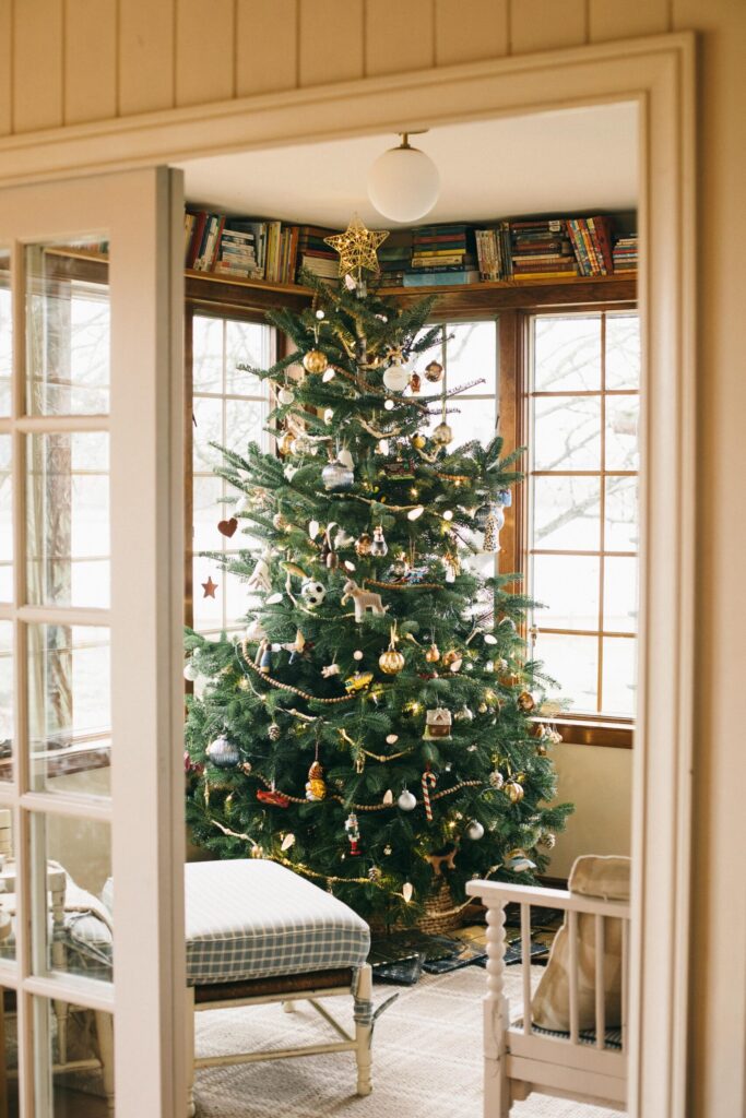 Image of a cottage Christmas tree with a wood bead garland and blue ornaments