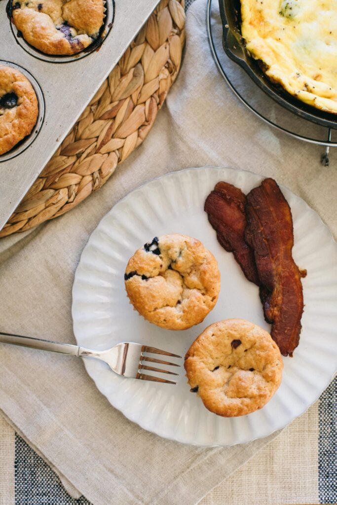 Image of healthy Blueberry Muffins on a table with bacon and eggs