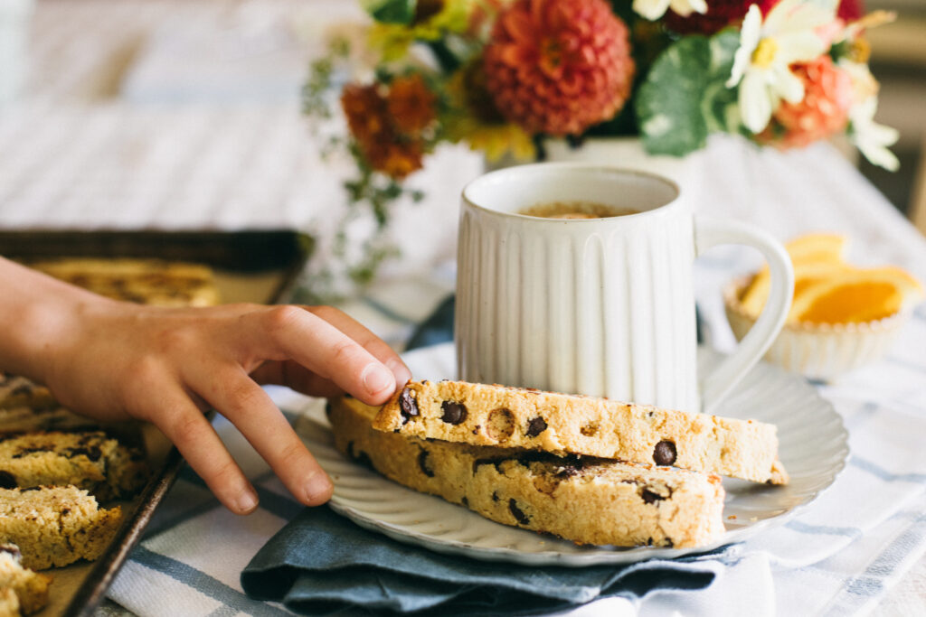 Image of a hand reaching out to grab an Orange Chocolate Chip Biscotti